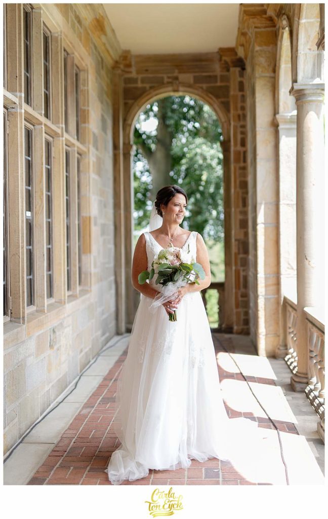 A bride stands in the light during her Fairfield University wedding in Fairfield CT