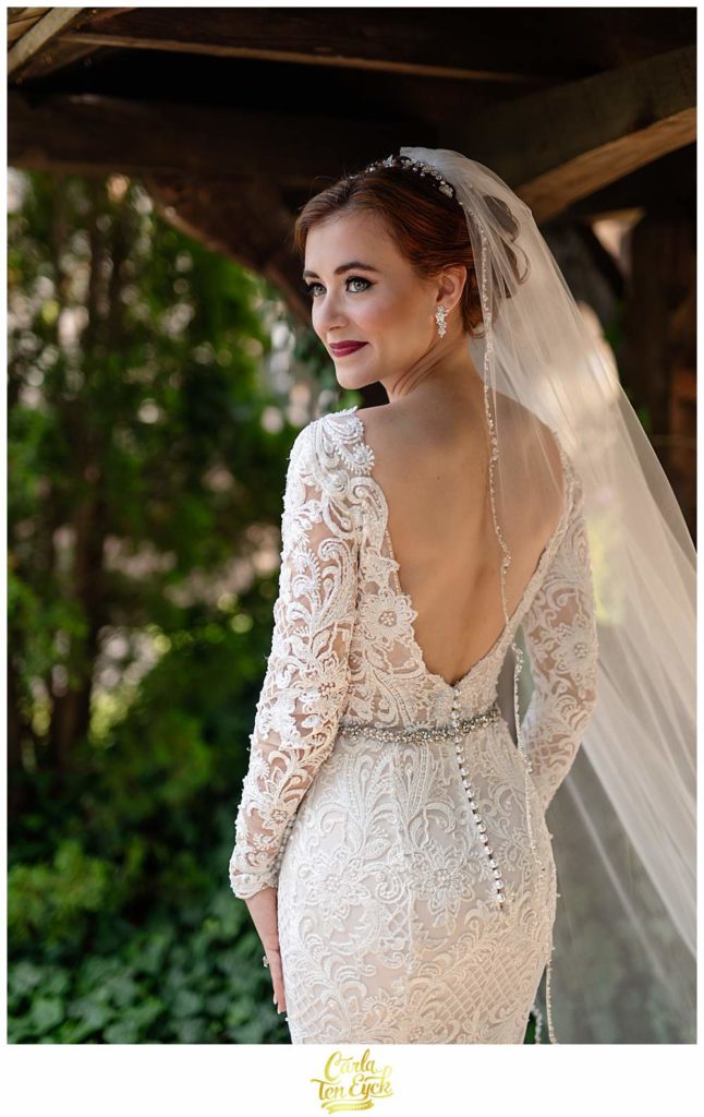 A bride stands by the ivy during her Bill MIller's Castle wedding in Branford CT