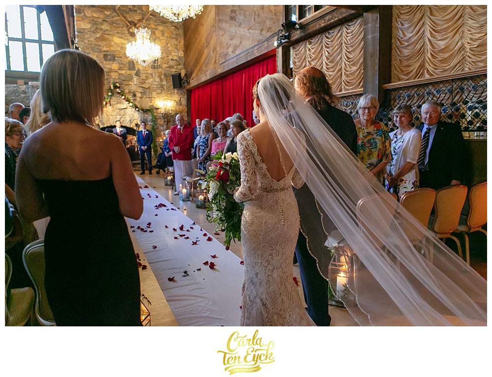 A birde walks down the aisle with her father at her Bill Millers' Castle wedding in Branford CT