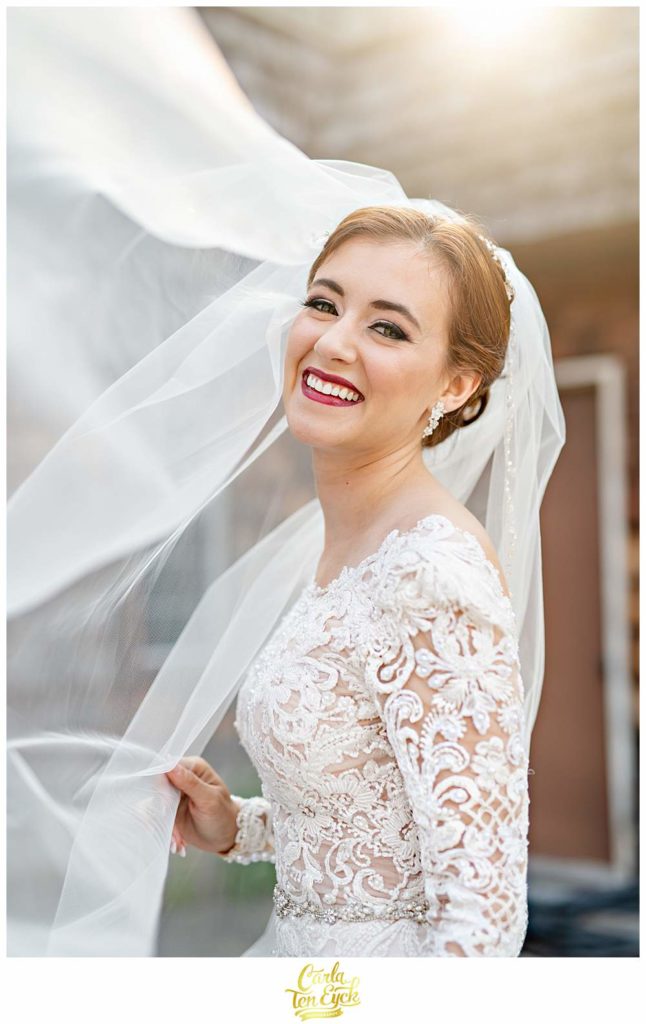 A bride laughs in the sunlight during her Bill Miller's Castle wedding in Branford CT