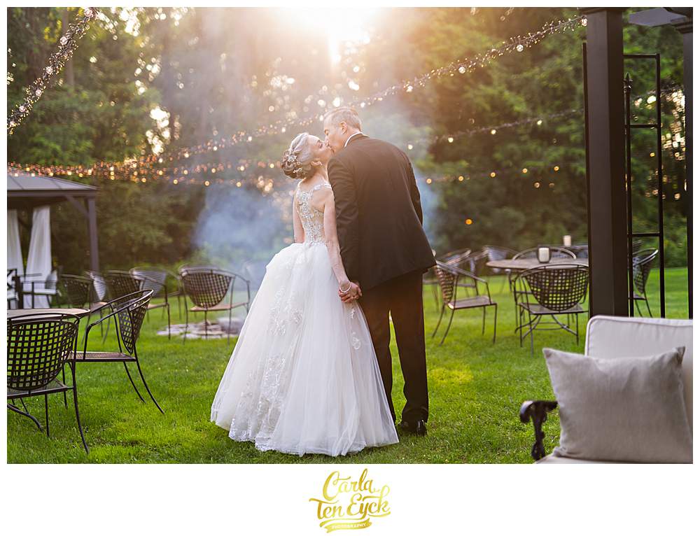 A couple kisses by the fire at their Lord Thompson Manor wedding in Thompson CT