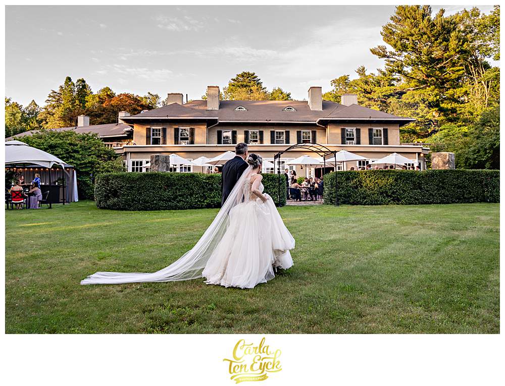 A couple walks during cocktail hour at their Lord Thompson Manor wedding in Thompson CT