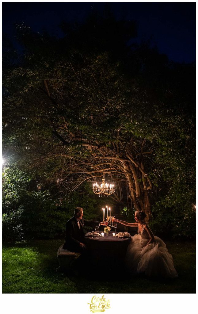 A bride and groom toast by candlelight at their magical Lord Thompson Manor wedding in Thompson CT