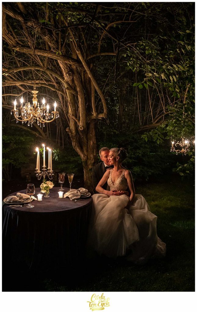 A bride and groom cuddle by candlelight at their Lord Thompson Manor wedding in Thompson CT