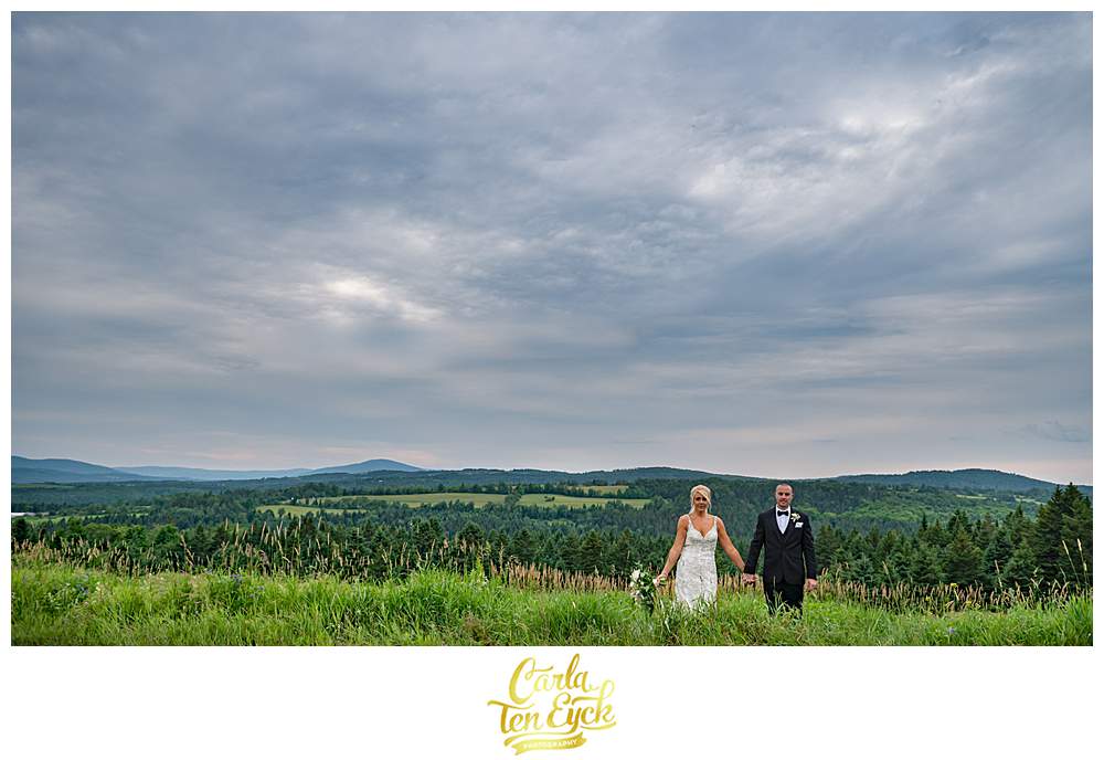 A couple poses for photos during their New Hampshire wedding by the mountains.