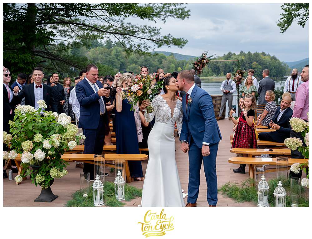 A couple kisses at their summer Camp Lenox wedding in Otis MA