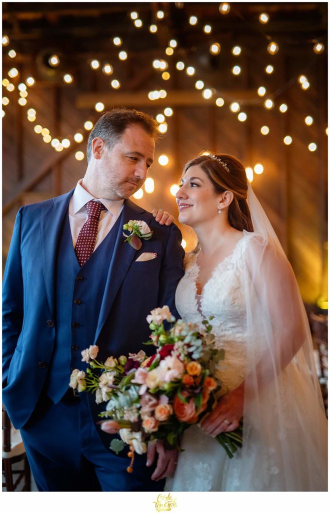 A bride and groom pose for photos during their autumn Saltwater Farm vineyard wedding in Stonington CT