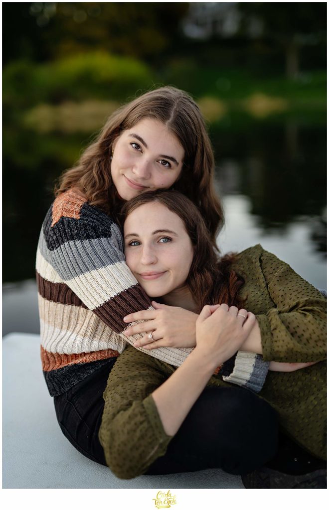 Two brides cuddle during their engagement session at Smith College in Northampton MA.