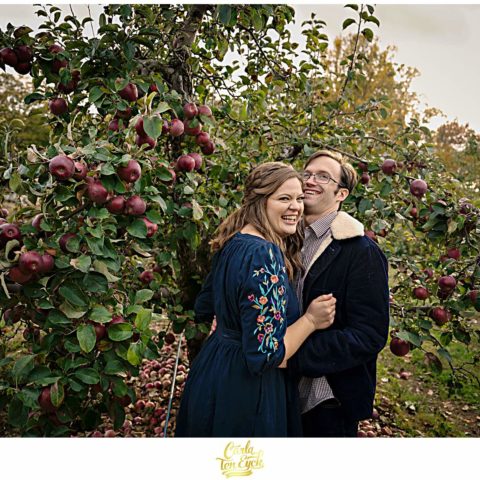 Couple poses for photos during their CT apple orchard engagement session in Glastonbury CT