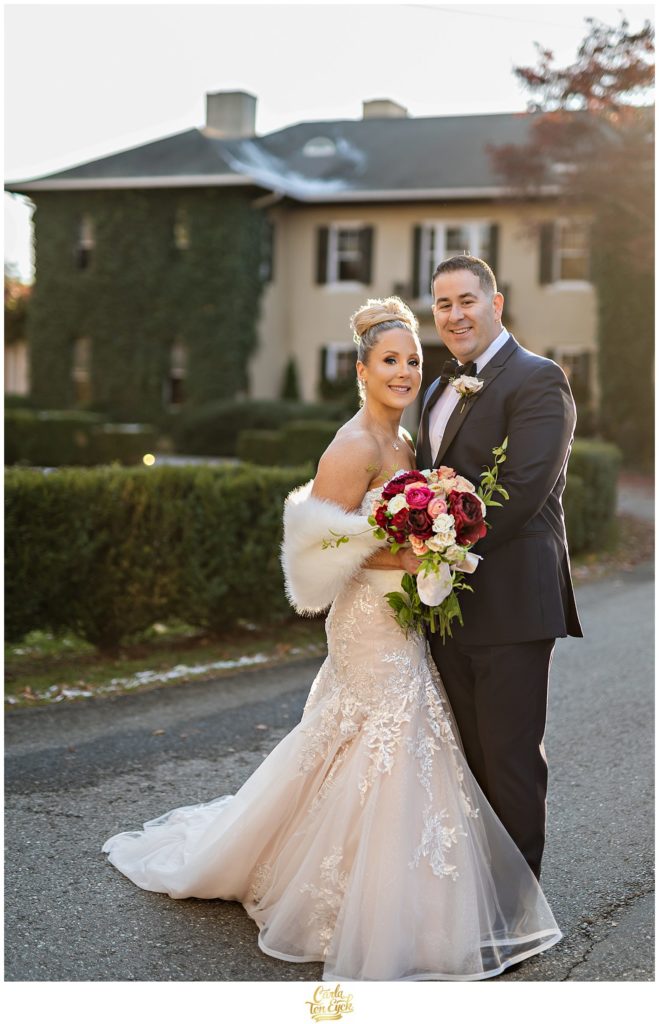 A couple poses for photos during their winter Lord Thompson Manor wedding in Thompson CT