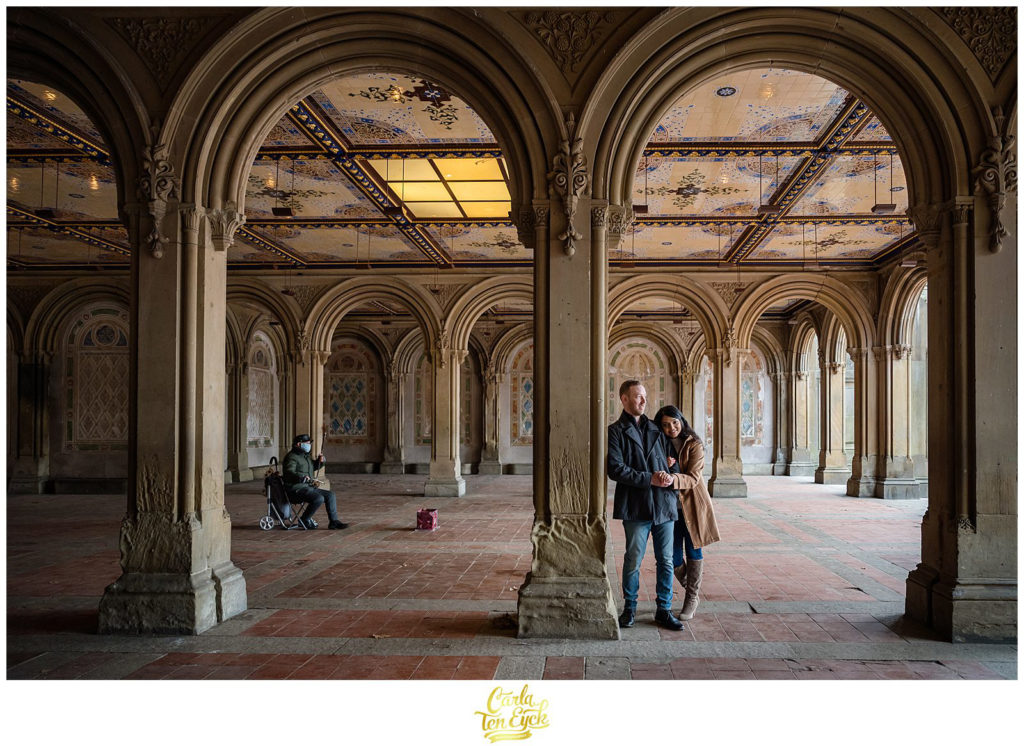 A couple snuggles during their winter Central Park engagement session