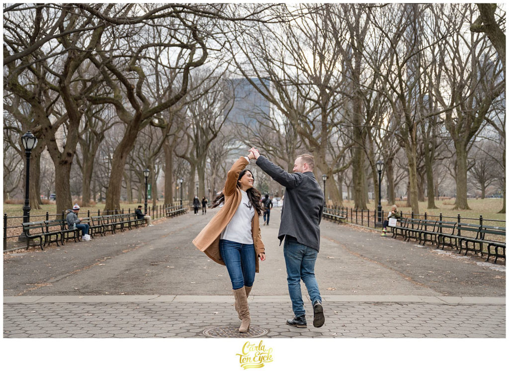 A couple dances along the iconic Mall in Central Park during their winter engagement session