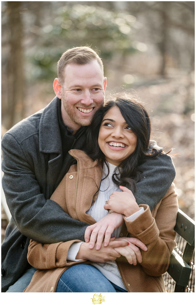 A couple laughs during their winter engagement session in The Ramble in Central Park in New York City 