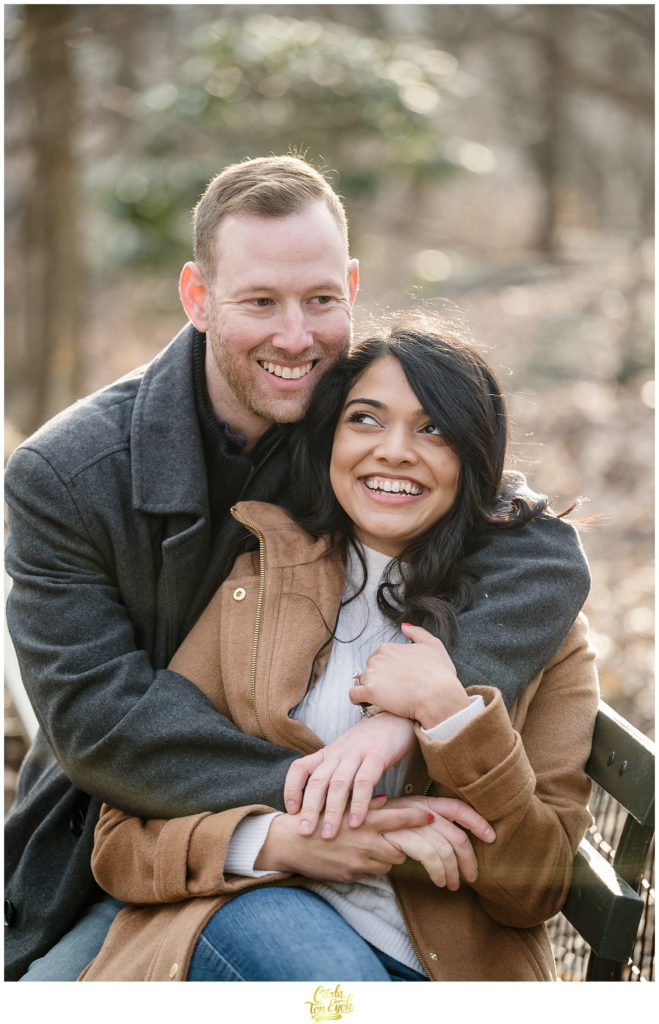 A couple laughs during their winter engagement session in The Ramble in Central Park in New York City