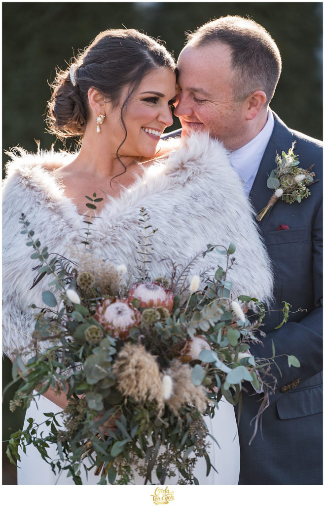 A bride and groom keep warm at their wedding at The Barns at Wesleyan Hills in Middletown CT