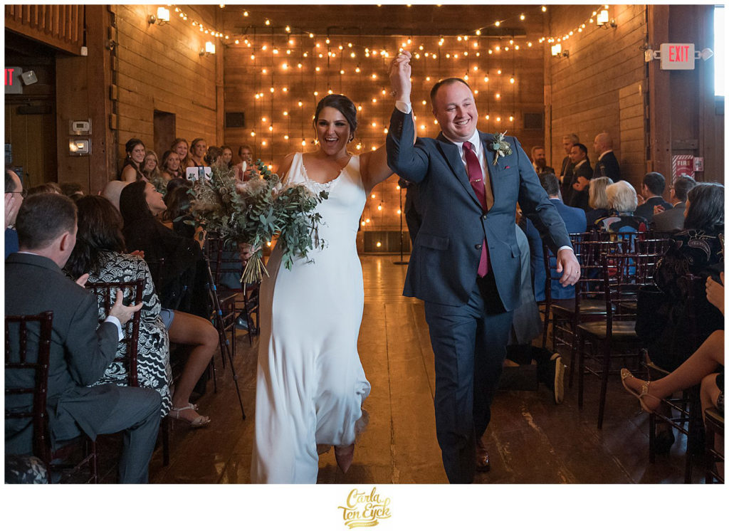 Just married! A bride and groom walk down the aisle at their wedding at The Barns at Wesleyan Hills in Middletown CT