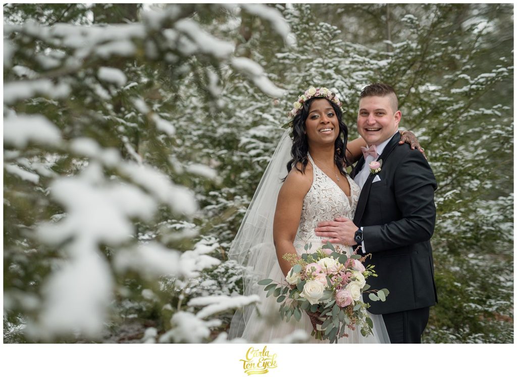A couple laughs in the snow during their wedding at The Pavilion at Crystal Lake in Middletown, CT