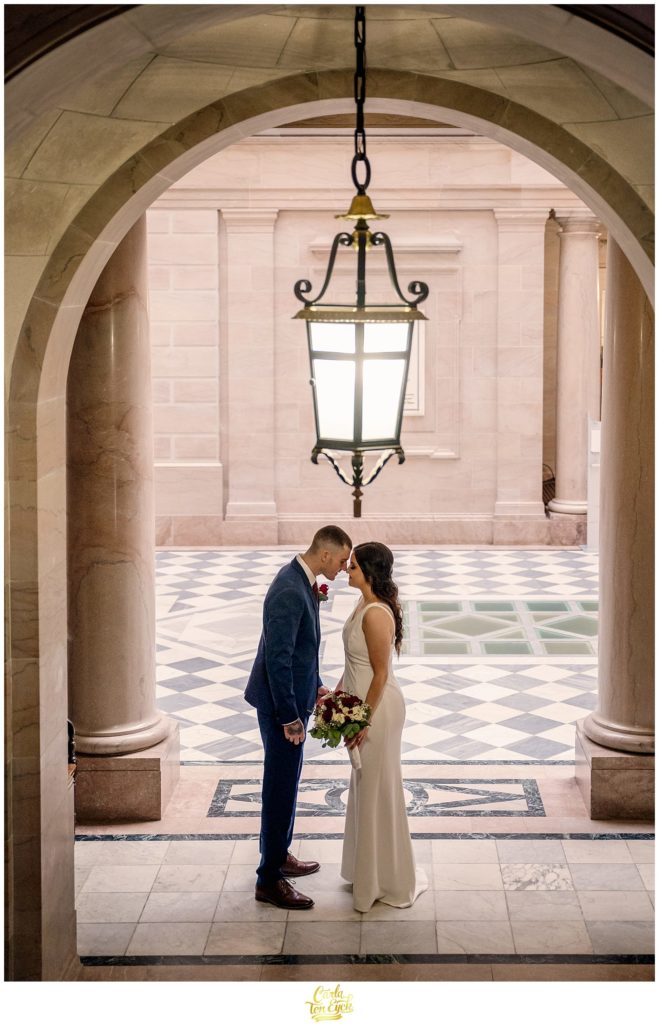 A couple cuddles for photos during their Hartford City Hall Spring elopement, in Hartford CT