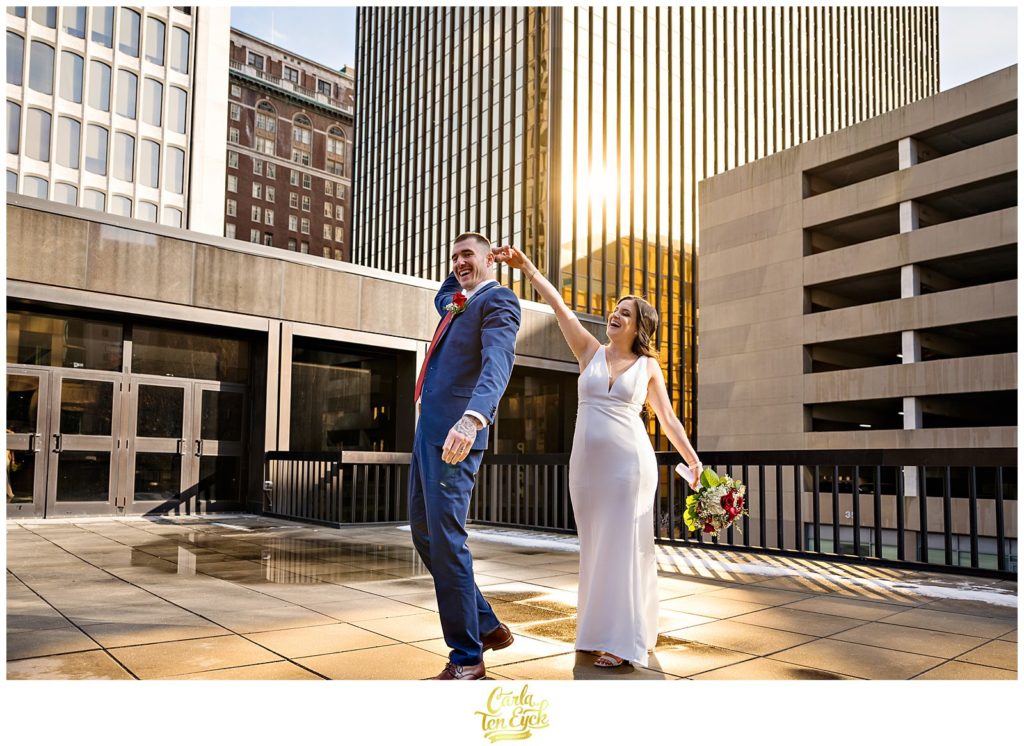A couple spins each other on a Hartford rooftop during their wedding photos at their Hartford City Hall Spring elopement, in Hartford CT